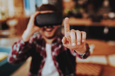 Happy Freelancer parmak puan test Vr. bulanık portre, neşeli gülümseyen beyaz adam takıyor sanal siyah Reality gözlükler oturan kapalı iken. Yenilik teknoloji kavramı