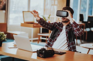 Mutlu Freelancer uzaktan çalışma ve test Vr. portresi neşeli beyaz adam takıyor sanal gerçeklik gözlükler oturup Danışma Laptop istimal ang becerikli alet tutan el kadar kapalı.