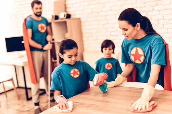 Happy Cute Super Heroes Family Cleaning Room. Mother with Kids Washing the Table at Home. Cleaning Day Concept. Kids Helping House Chores. Parent Concept. Domestic Concept.