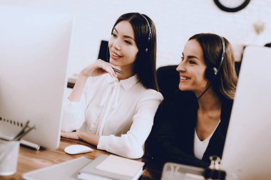 Çağrı merkezinde çalışan iki genç gülümseyen kadınlar. Bilgisayar Yöneticisi. İşyeri kız. Danışman mikrofon ile. Müşteri hizmet anlayışı. Ofis operatör. Gülümseyen kadın ofiste.