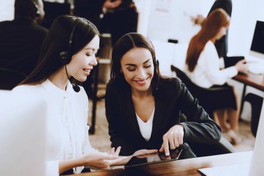 Çağrı merkezinde çalışan iki genç gülümseyen kadınlar. Bilgisayar Yöneticisi. İşyeri kız. Danışman mikrofon ile. Müşteri hizmet anlayışı. Ofis operatör. Gülümseyen kadın ofiste.