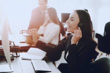 Oturma ve çağrı merkezinde çalışan genç kadın. Bilgisayar Yöneticisi. İşyeri kız. Danışman mikrofon ile. Müşteri hizmet anlayışı. Kulaklık kadında. Ofis operatör.