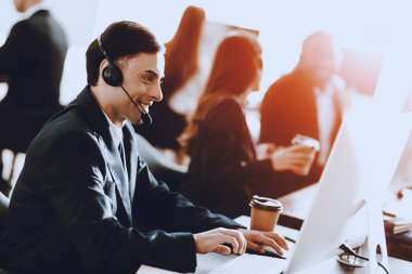 Oturma ve çalışma çağrı merkezi, Genç adam. Bilgisayar Yöneticisi. İşyeri adam. Danışman mikrofon ile. Müşteri hizmet anlayışı. Kulaklık kadında. Ofis operatör.