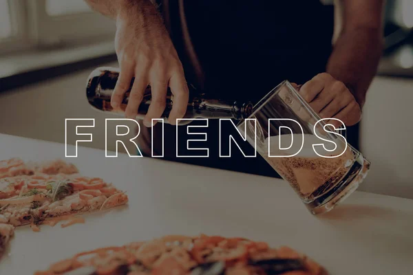 Close-Up. Guy Pours Beer into Glass. Man Eat Pizza. Man Drink Beer from Dark Bottle. Friend Stay in Kitchen. Best Friend Having Fun. Cheerful Man Smiling. Guy on Party Celebration.