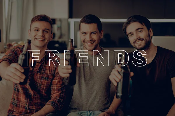 Three Men Drink Beer. Guys Hold Dark Bottles. Guys Happy Together. Friends Sit on Couch. Cheerful Best Friend Forever. Men Having Fun. Friends Smiling and Posing for Photo. Men Spend Time Together.