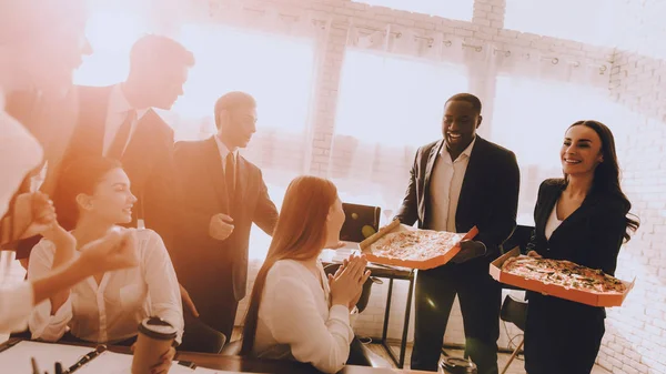 Team of Managers Have Lunch in Modern Office. Rest after Business Meeting. Modern Office Concept. Cooperation with Colleagues. Businessman with Team. Pizza in Box. Businessman in Suit.