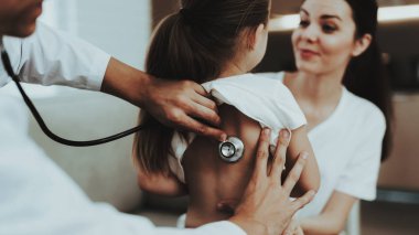 Soğuk ile kırmızı fularlı küçük kız ziyaret Doktor. Genç kız hasta. Oda beyaz kanepe. Doktor üniformalı. Hastalık kavramı. Sağlık ve sağlıklı yaşam konsepti. Anne ile kızı.