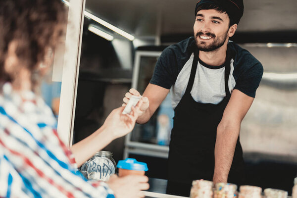 Young Woman in Shirt Buying Coffee in Food Truck. Promenade in Town. Summer Day. Girl in Checkered Shirt. Street Food Concept. Cup of Coffee. Buying Food Outdoor. Food in Town. Selling Snacks.