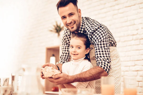 Cook Food at Home. Happy Family. Father's Day. Girl and Man Cooking Smiling Man and Child at Table. Spend Time Together. Food on Table. Egg in Bowl. Pour Flour. Cook Dough. Dough in Hands.