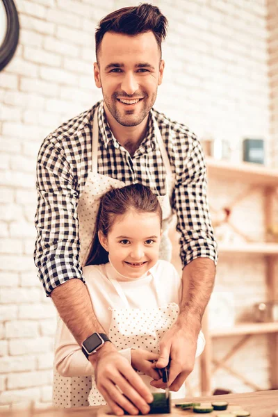 Cook Food at Home. Happy Family. Father\'s Day. Girl and Man Cook Food. Man and Child at Table. Spend Time Together. Grate Cheese. Grater in Hand. Tomatoes and Cucumber. Kitchen Process. Rub Grated.