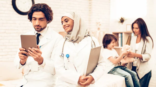 Portrait of Smiling Arabic Doctors Pediatricians. Confident Muslim Doctors Standing in Office. Child at the Pediatrician. Hospital Concept. Healthy Concept. Child Patient Visiting Doctor.