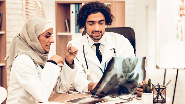 Arabic Doctors Holding X-Ray, Medical Consultation. Muslim Doctors Having Consultation in Office. Arabic Doctors Holding X-Ray, Medical Consultation. Hospital Concept. Healthy Concept.