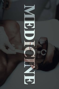 Genç adam güzellik salonuna geldi. Tıp masaj. Kanepede döşenmesi. Yordamı için hazırlanıyor. Modern Spa salonu. Vücut Temizleme. Çıplak gülümseyen hasta. Koruyucu gözlük. Epilasyon jeli.