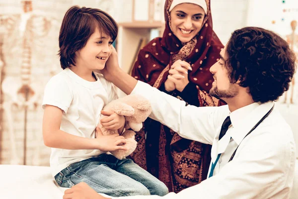 Arabic Doctor Giving Toy to Little Cute Patient. Confident Muslim Male Doctor. Child at the Pediatrician. Hospital Concept. Healthy Concept. Child Patient Visiting Doctor. Healthcare And Medicine.