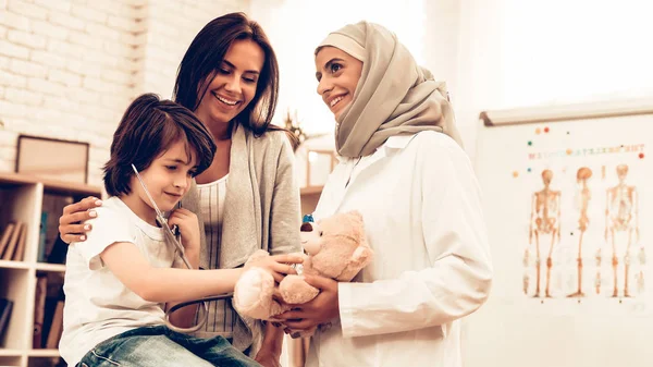 Arabic Doctor Giving Toy to Little Cute Patient. Confident Muslim Female Doctor. Child at the Pediatrician. Hospital Concept. Healthy Concept. Child Patient Visiting Doctor. Healthcare And Medicine.