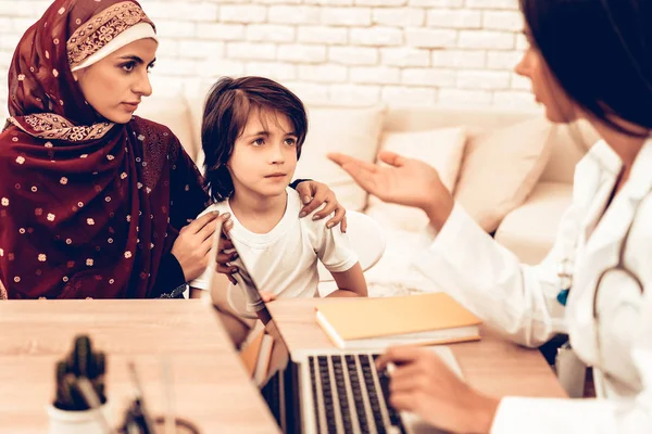 Muslim Family at Doctor\'s Appointment Office. Child at the Pediatrician. Hospital Concept. Healthy Concept. Child Patient Visiting Doctor. Arabic Mother with Little Boy. Healthcare Concept.