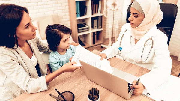 Mom Giving to Arabic Doctor Medical Examinations. Confident Muslim Female Doctor. Child at the Pediatrician. Hospital Concept. Healthy Concept. Child Patient Visiting Doctor.