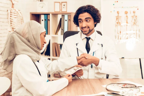 Arabic Doctors Counting Money After Work, Payday. Muslim Doctors Counting Dollars in Office. Arabic Doctors Holding Money, Medical Consultation. Hospital Concept. Healthy Concept. Healthcare