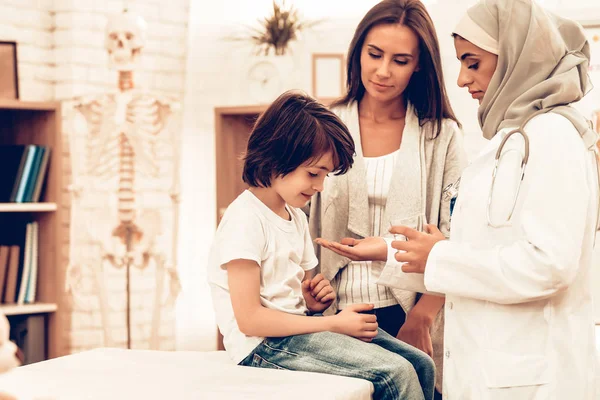 病気の少年の横になっているベッドに与える医学をアラビア語博士 自信を持ってのイスラム教徒女性医師が医学のガラスを与えます 小児科医の子 病院のコンセプトです 健康的な概念 子供患者訪問医師 — ストック写真