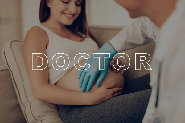 医疗咨询 医生探明胃 蓝色医疗手套 孕妇照顾孩子 肚皮女孩预期怀孕 肚皮躺在沙发上 怀孕的女孩微笑 每日预期寿命母亲 — 图库照片