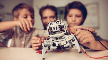 Baba ve oğlu evde Robot inşa sakallı. Genç çocuk gömlek. Kapalı sevinç. Modern hobi kavramı. Modern teknoloji. Robot mühendislik kavramı. Genç adam yenilik için eğlenceli sakallı.