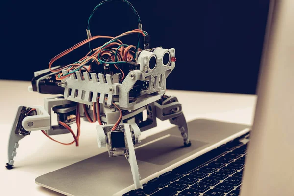 クローズ アップ テーブルの上のノート パソコンと小型灰色ロボット 現代の技術 ロボット工学の概念 モダンな楽しいコンセプト 楽しみのための技術革新 電子ロボット デジタル — ストック写真