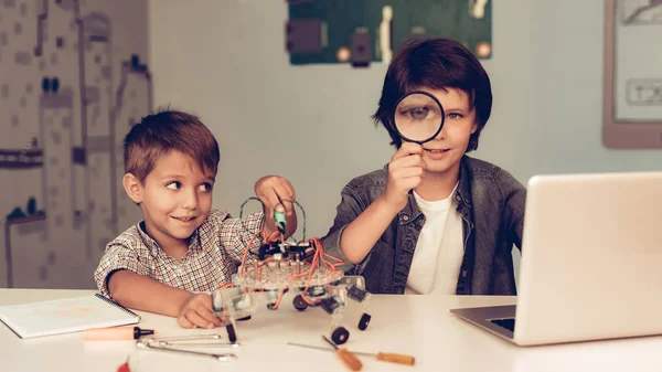 Dos Chicos Sentados Mesa Construyendo Robots Chico Joven Con Camisa — Foto de Stock