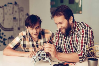 Baba ve oğul evde Robot inşa sakallı. Genç çocuk gömlek. Kapalı sevinç. Modern hobi kavramı. Modern teknoloji. Robot mühendislik kavramı. Genç adam yenilik için eğlenceli sakallı.
