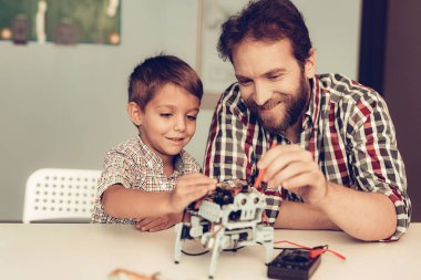 Baba ve oğul evde Robot inşa sakallı. Genç çocuk gömlek. Kapalı sevinç. Modern hobi kavramı. Modern teknoloji. Robot mühendislik kavramı. Genç adam yenilik için eğlenceli sakallı.