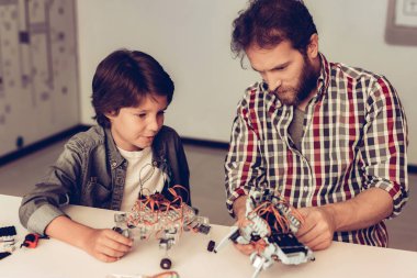 Baba ve oğul evde Robot inşa sakallı. Genç çocuk gömlek. Kapalı sevinç. Modern hobi kavramı. Modern teknoloji. Robot mühendislik kavramı. Genç adam yenilik için eğlenceli sakallı.