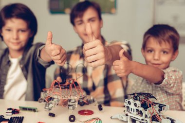 Genç ve iki oğlum evde Robot inşa. Genç çocuk gömlek. Kapalı sevinç. Modern hobi kavramı. Modern teknoloji. Robot mühendislik kavramı. Genç Robor ile. Eğlenmek için yenilik.