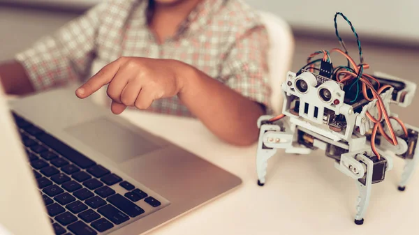 Little Boy in Shirt Programming Robot at Home. Young Boy in Shirt. Using Laptop. Modern Hobby Concept. Modern Technology. Robot Engineering Concept. Innovation for Fun. Teenager with Robor.