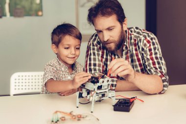 Baba ve oğul evde Robot inşa sakallı. Genç çocuk gömlek. Kapalı sevinç. Modern hobi kavramı. Modern teknoloji. Robot mühendislik kavramı. Genç adam yenilik için eğlenceli sakallı.
