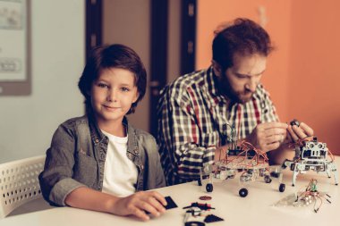 Baba ve oğul evde Robot inşa sakallı. Genç çocuk gömlek. Kapalı sevinç. Modern hobi kavramı. Modern teknoloji. Robot mühendislik kavramı. Genç adam yenilik için eğlenceli sakallı.