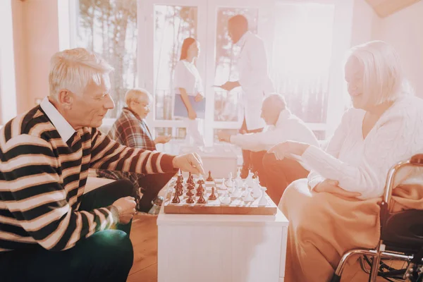 Мужчина Женщина Играют Шахматы Дом Престарелых Доктор Медсестра Стоят Рядом — стоковое фото