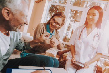 Mutlu aile birlikte. Yaşlı adam evin anahtarları devraldığınız. Siyah saçlı Doktor gülümseyerek. Emekli kişi işaretler sözleşme. Yaşlı adam Ahit. Genç kadın Sit. Bakım evinde güneş gün.