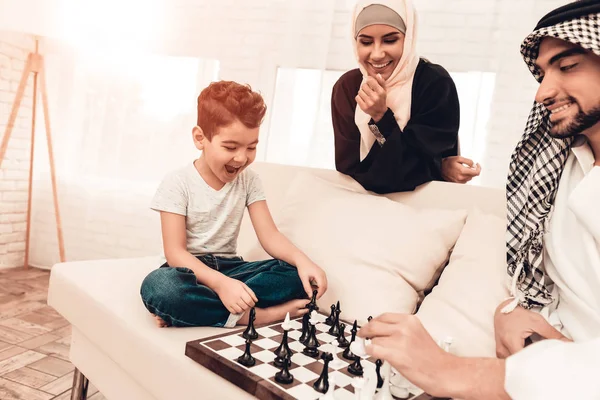 阿拉伯男孩在家里和父亲下棋 健康的生活方式概念 微笑的母亲 穆斯林家庭 微笑的男孩在家里 年轻的阿拉伯人 棋盘游戏 室内娱乐 — 图库照片