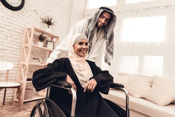 Young Arabian Woman on Wheelchair with Husband. Arabian Family Concept. Sitting on Wheelchair. Disabled Woman. Smiling Man. Sitting Muslim Woman. Happy Young Family. Husband with Wife.