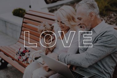 Kadın köpeği tut. Adam Sit dizüstü bilgisayar ile .