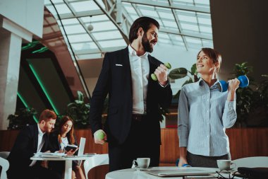 Kurumsal spor yaşam tarzı. Sağlık iş adamları. Ofis çalışanları dumbell ile çalışma. İşçiler Fitness egzersizleri yapıyor. Yoga pratik. Gülümseyen için sağlıklı kadın çalışan adam.