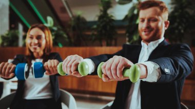 Kurumsal spor yaşam tarzı. Sağlık iş adamları. Ofis çalışanları dumbell ile çalışma. İşçiler Fitness egzersizleri yapıyor. Yoga pratik. Gülümseyen için sağlıklı kadın çalışan adam.