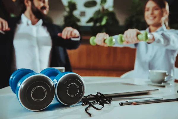 Corporate Sport Lifestyle. Healthcare of Business People. Office Workers Working with Dumbbells. Workers doing Fitness Exercises. Yoga Practice. Happy Office Managers. Close up Dumbbell on the Table.