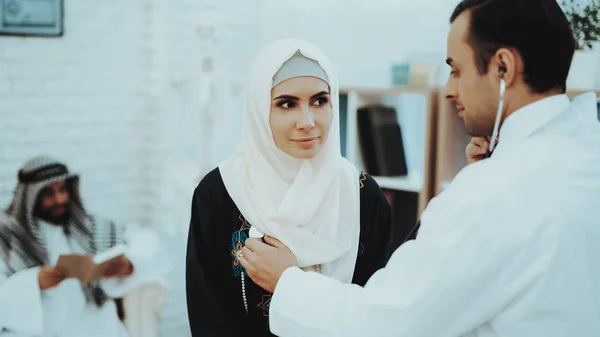 Arabic Doctor Checking Heartbeat a Muslim Woman. Arabic Male Doctor Examining a Woman. Consultation at Clinic. Reception of Therapist. Discussing Diagnosis. Examination. Medical Concept.