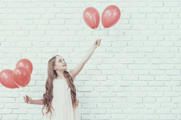 穿红色气球的女孩站在白色的房间里 年轻的女孩 红色气球 长头发 白色连衣裙 快乐的女孩 庆祝理念 三月份的假期 手里拿着气球金发 — 图库照片