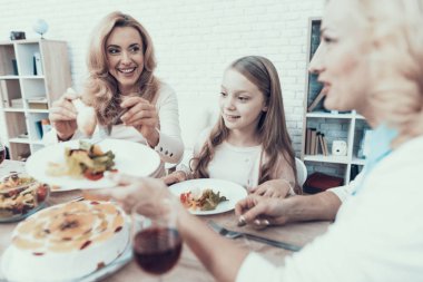 Mutlu aile kutluyor Doğum günü evde oturan. Pasta masada. Mutlu bir aile. Anne ile kızı. Gülümseyen kadın. Gülümseyen büyükanne. Kutlama kavramı. Bir bardak şarap. Meyve plaka üzerinde.