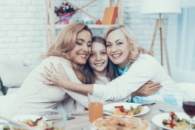 Aile evde kızımın Doğum günü kutluyor. Pasta masada. Mutlu bir aile. Anne ile kızı. Gülümseyen kadın. Gülümseyen büyükanne. Kutlama kavramı. Bir bardak şarap. Birlikte sarılma.