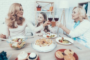 Mutlu aile kutluyor Doğum günü evde oturan. Pasta masada. Mutlu bir aile. Anne ile kızı. Gülümseyen kadın. Gülümseyen büyükanne. Kutlama kavramı. Bir bardak şarap. Meyve plaka üzerinde.