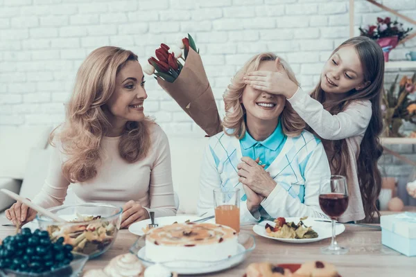 Family Preparing Surprize for Grandmother at Home. Cake on Table. Happy Family. Mother with Daughter. Smiling Women. Smiling Grandmother. Celebration Concept. Glass of Wine. Closed Eyes.