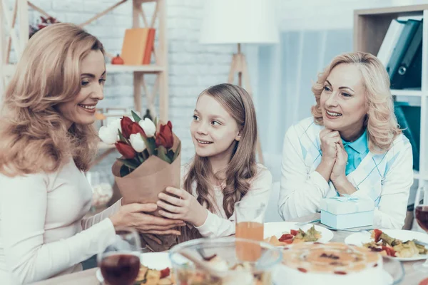Family Celebrating Mother\'s Birthday at Home. Cake on Table. Happy Family. Mother with Daughter. Smiling Women. Smiling Grandmother. Celebration Concept. Glass of Wine. Bouquet of Tulips.