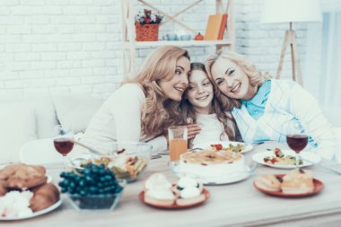 Aile evde kızımın Doğum günü kutluyor. Pasta masada. Mutlu bir aile. Anne ile kızı. Gülümseyen kadın. Gülümseyen büyükanne. Kutlama kavramı. Bir bardak şarap. Birlikte sarılma.